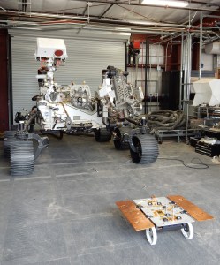 A CADRE test rover appears to catch the attention of the much larger engineering model of NASA’s Perseverance rover, called OPTIMISM, at JPL’s Mars Yard. CADRE will demonstrate how multirobot missions can record data impossible for a single robot to achieve – a tantalizing prospect for future missions. 